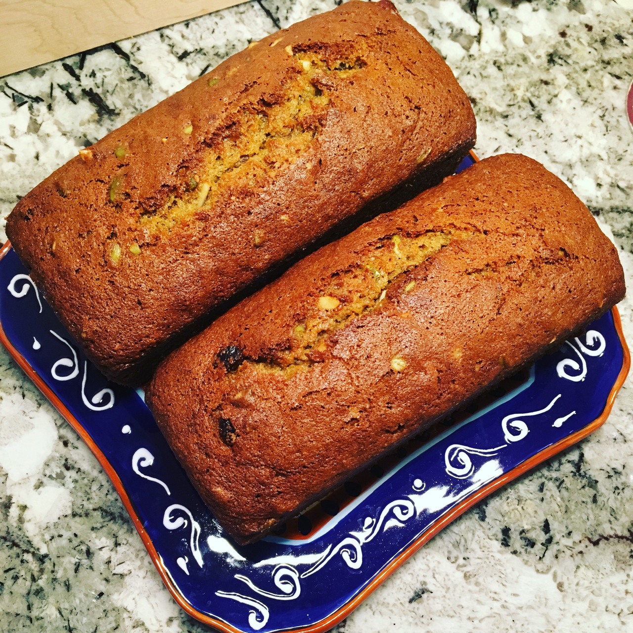 Two small, intensely colored loaves of sweet bread made from persimmon fruit.